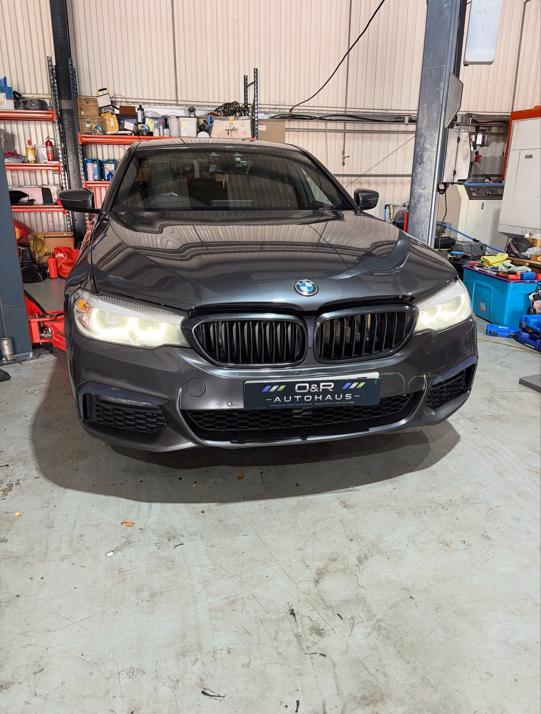 A BMW 5 Series between the ramp posts at O&R Autohaus